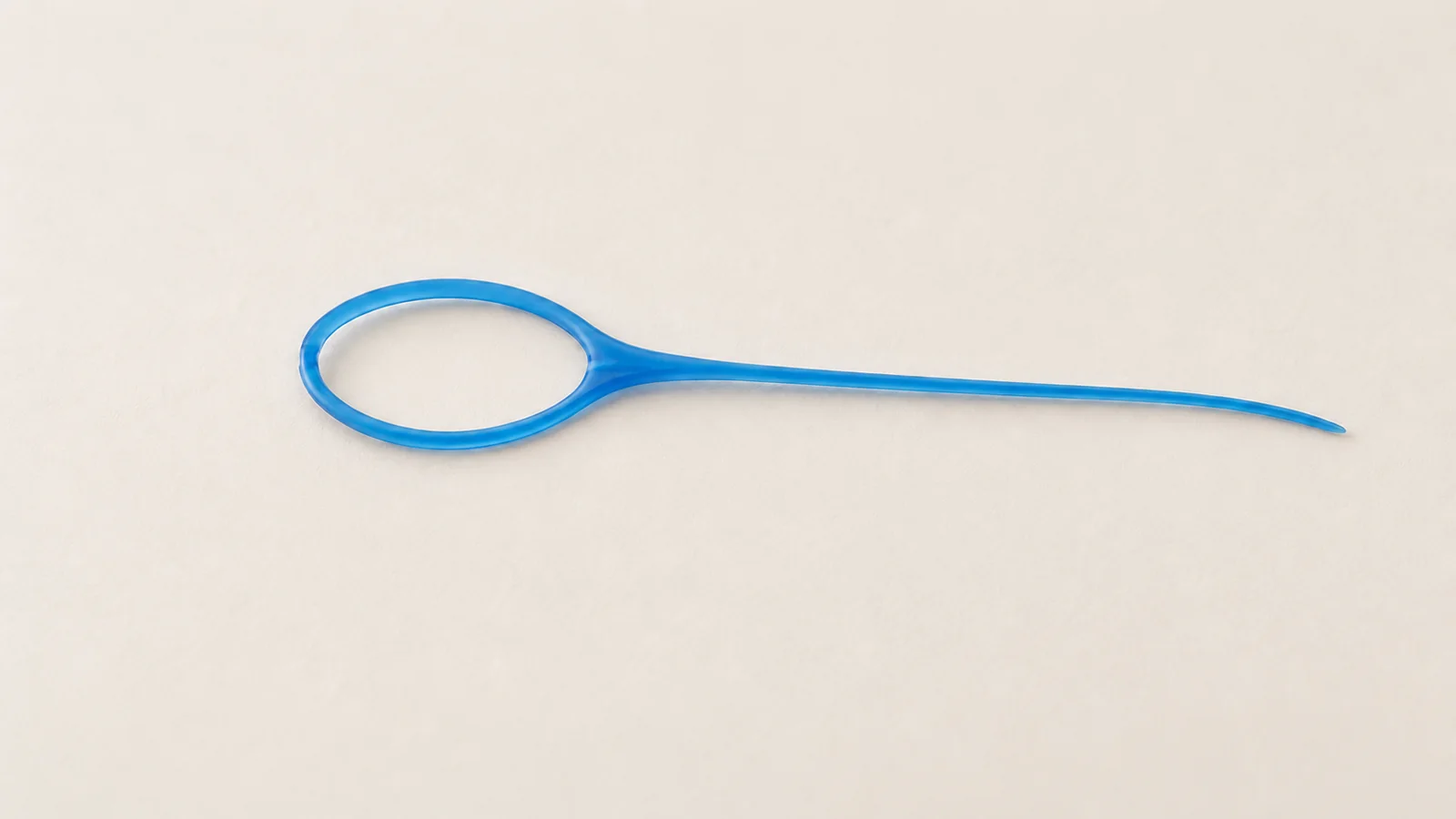 Close-up of the loop and thin flexible tail of a dental floss threader
